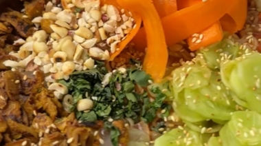 Desi-style cold noodles topped with soya keema, pickled cucumber, carrots, and peanuts